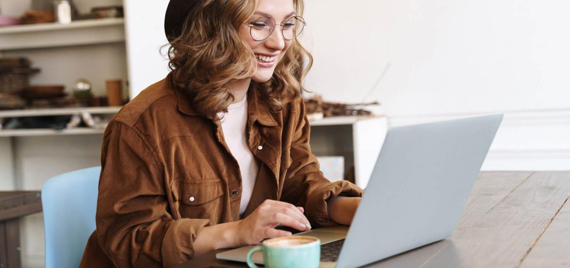 image-of-cheerful-woman-working-with-laptop-while-CNX4RJP.jpg